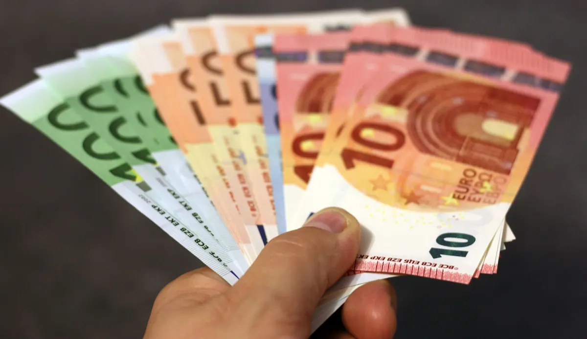 Ruka drží vějíř eurových bankovek