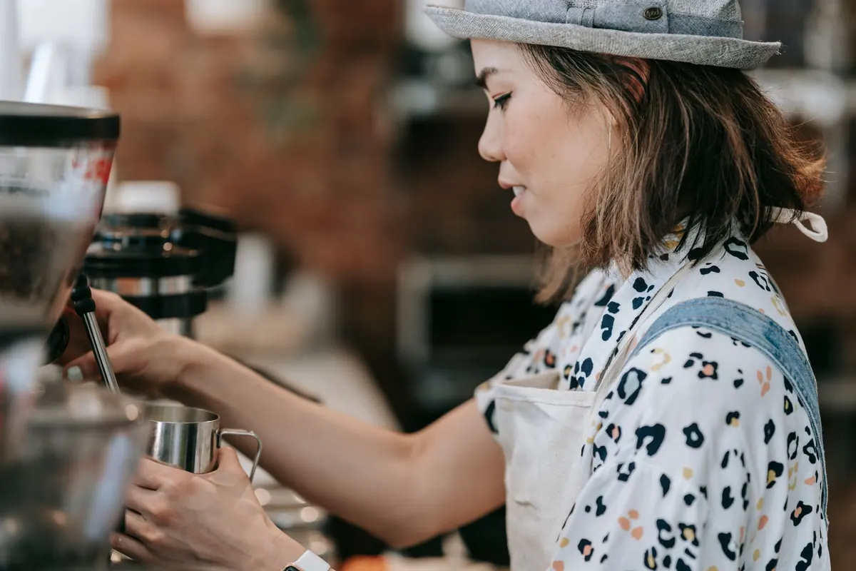 Barmanka připravuje kávu u espresso přístroje