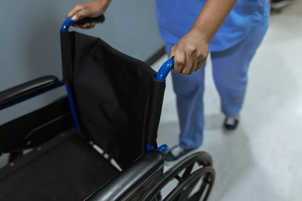 Zdravotník tlačí invalidní vozík na chodbě