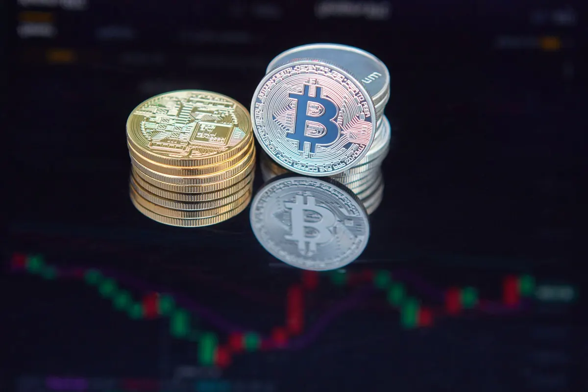 Bitcoinové mince před grafem cenového vývoje
